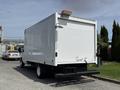A 2018 Ford E-450 box truck viewed from the rear with a simple white exterior and a yellow light above the back door