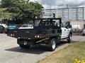 A 2017 Ford F-550 truck with a black flatbed and rear lights visible parked on the street