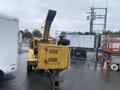 A yellow 2010 Vermeer Corporation BC1000XL wood chipper with a large chute for outputting wood chips and a robust body designed for heavy-duty chipping tasks