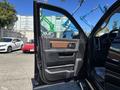 A 2015 RAM 1500 truck with its driver's side door open, showcasing the interior features including the door panel and controls