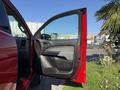 A red 2018 GMC Canyon with the driver's side door open showcasing the interior door panel and handle