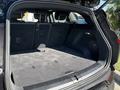 The rear trunk space of a 2023 Fisker Ocean with a flat carpeted surface and no items inside