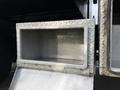 A metal storage compartment with a diamond plate design attached to a 2015 Ford F-350 truck