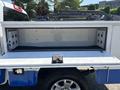 A 2017 Chevrolet Colorado features a truck bed with an open storage compartment showing side walls with circular cutouts and a black floor