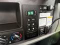 Control panel of a 2016 Peterbilt 348 featuring buttons for gear selection and operational modes along with indicator lights and warning labels
