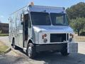 A silver 2008 Workhorse W62 box truck with a flat front and large windshield featuring a yellow beacon light on top and a grille cover at the front
