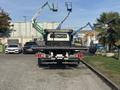 A 2022 Freightliner M2 106 tow truck with a flatbed is parked facing forward showcasing its rear lights and towing equipment.