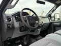 Interior view of a 2012 Ford F-550 showing the steering wheel dashboard and seats in a gray fabric upholstery