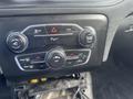 Dashboard controls of a 2015 Dodge Charger featuring knobs and buttons for temperature volume and air conditioning settings