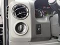 Dashboard controls of a 2014 Ford Econoline including air vent headlight switch and various indicators