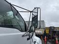 A 2011 Ford F-650 with large side mirrors reflecting raindrops and showing a close-up view of the driver's side mirror