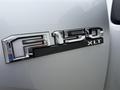 Close-up of a chrome emblem displaying the text F-150 XLT on a silver Ford F-150 truck