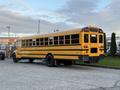 2014 International 4300 school bus with a bright yellow exterior black stripes and multiple windows along the side