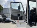 A white 2022 Lion Lion6 truck with an open driver's door showcasing its interior panel and control features