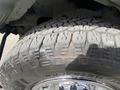 Close-up of a rugged tire on a 2022 GMC Savana showcasing deep tread patterns and shiny alloy rim detailing