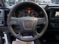 Steering wheel of a 2017 GMC Sierra 3500HD with the GMC logo in the center and controls on the spokes
