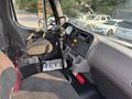 Interior of a 2016 Freightliner M2 106 showing the driver's seat steering wheel dashboard gear shifter and controls