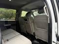 The interior of a 2019 Ford F-350 SD showing the back seat area with two bench seats upholstered in light gray fabric
