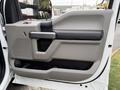 Door panel of a 2020 Ford F-550 featuring a gray armrest handle and modular storage compartments