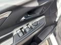 Interior view of a 2023 Chevrolet Bolt EV driver's side door panel featuring controls for windows and door locks
