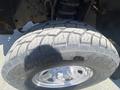 Close-up of a rugged tire on a 2016 Ford F-350 SD showcasing deep treads and a polished silver wheel