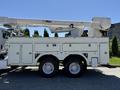 A 2013 International 7400 bucket truck with a white utility body and an Altec aerial lift mounted on top
