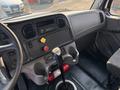 Interior view of a 2016 Freightliner M2 106 featuring the dashboard gear shift radio and control panel with various buttons and a fire extinguisher mounted below