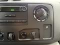 Dashboard controls of a 2019 Ford Econoline featuring audio system buttons a temperature control dial and a rotary knob for additional settings