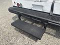 The rear step of a 2011 Workhorse W62 featuring a rectangular black metal platform with textured surface mounted on a sturdy metal frame