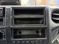 The dashboard of a 2015 Hino 195 displaying empty storage compartments and control knobs without any visible instruments or media devices