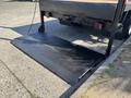 The rear of a 2014 RAM 5500 with a black diamond plate loading ramp extended on the ground