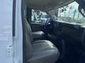 Interior view of a 2022 GMC Savana showing two front seats and the dashboard with controls and storage compartments