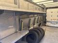 Interior of a 2012 Ford E-450 with metal shelves along the side and several tires stacked on the floor
