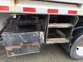 A close-up view of the undercarriage of a 2011 Dodge Ram 5500 showing a metal fuel tank and a step with textured grip for access to the truck's bed