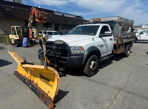 A 2016 RAM 5500 truck with a snow plow attached at the front and a dump bed in the back