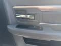 Interior door handle and window control panel of a 2014 RAM 5500 featuring a chrome handle and black window button