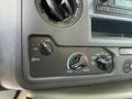 Dashboard controls of a 2023 Ford E-450 showing knobs for fan speed temperature settings and air conditioning functions
