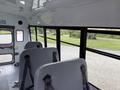 Interior view of a 2013 Chevrolet Express with gray seats and large windows on one side