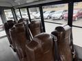 Interior of a 2021 Ford Econoline showing brown leather seats with seatbelts arranged in a row