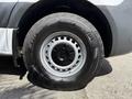 Close-up of a wheel and tire of a 2022 Mercedes-Benz Sprinter showcasing a silver rim and rugged black tire tread