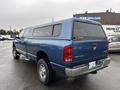 A blue 2006 Dodge Ram 2500 pickup truck with a cap on the bed and chrome accents on the wheels