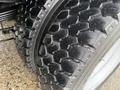 Close-up of a thick, rugged tire from a 2021 Ford F-550 showcasing its deep tread pattern and textured surface