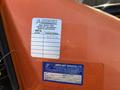 A close-up of a service label on an orange 2012 JLG E400AJFN lift indicating completed service hours and maintenance information