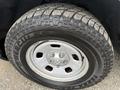 A close-up of a 2016 RAM 1500 tire showcasing a Hercules all-terrain tire tread and a silver steel wheel with five lug nuts