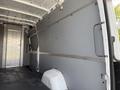 Interior view of a 2023 Mercedes-Benz Sprinter showing a spacious cargo area with gray side panels and an open rear door