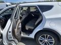 A 2018 Hyundai Santa Fe with an open passenger door revealing beige leather seats in the rear row and a sleek interior design