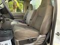 Interior view of a 2010 Ford F-550 showing the front driver's seat with gray fabric upholstery and a seat adjustment control on the side