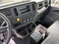 Interior cockpit of a 2025 Peterbilt 536 featuring a steering wheel dashboard panel with controls and a central console with switches and cup holders