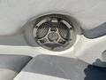 Close-up of a chrome speaker embedded in a boat seat with a textured silver grille and white vinyl upholstery