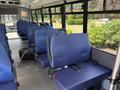 Interior of a 2020 Chevrolet Express bus featuring several blue fabric seats with seatbelts arranged in rows